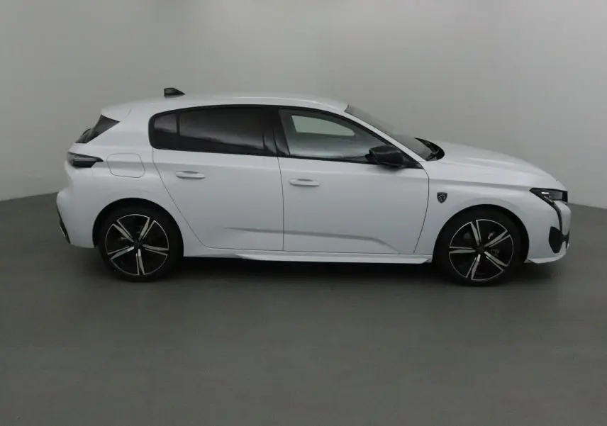 Profil côté gauche d'une Peugeot 308 blanche Okenite 2025 avec jantes noires et vitres teintées.