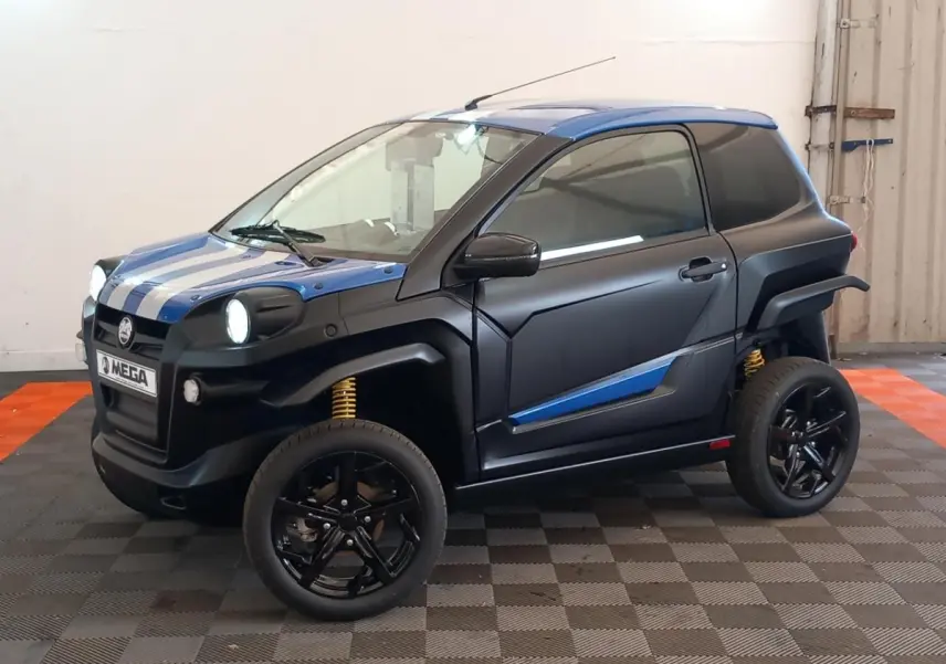 Vue 3/4 avant droite de l'AIXAM MEGA E-SCOUTY EVO bleu avec bandes blanches, jantes noires et suspensions jaunes visibles.