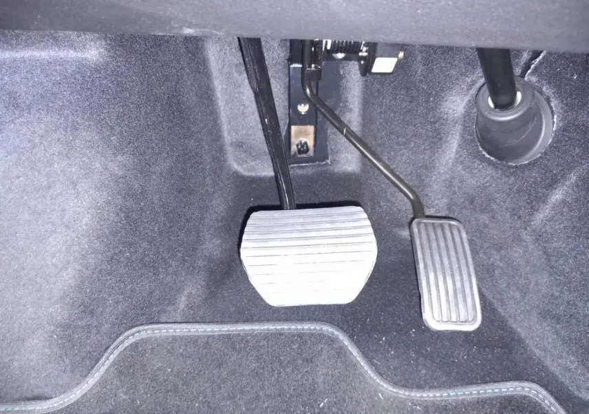 Vue rapprochée des pédales d’accélérateur et de frein d’une Aixam Mega E-Scouty Evo 2026 bleu électrique.