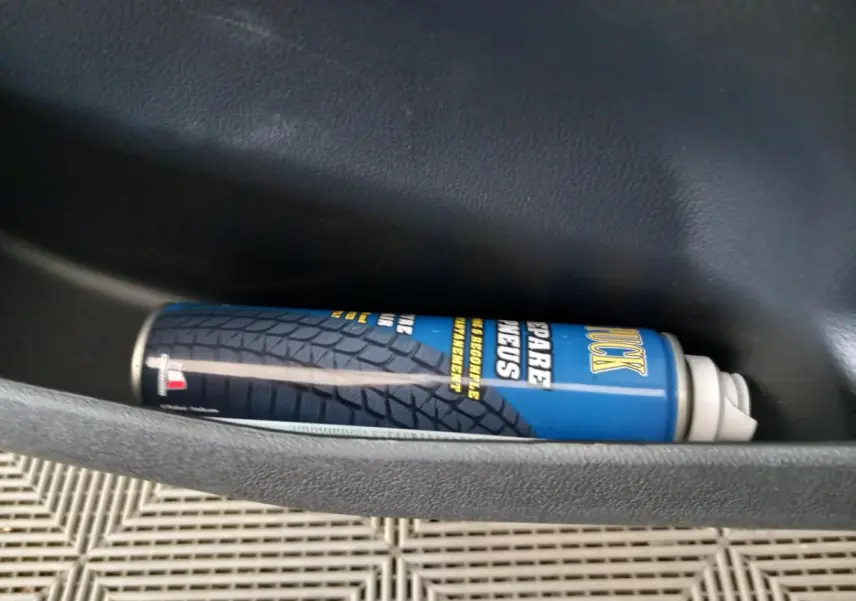 Gros plan sur une bombe de réparation de pneus bleue dans la porte intérieure d'une Aixam MEGA E-Scouty Evo 2026.