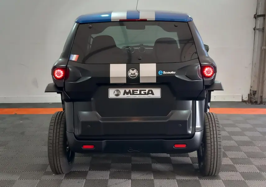 Vue arrière d’une Aixam MEGA E-Scouty Evo 2026 noire avec bandes blanches et feux arrière allumés en intérieur.