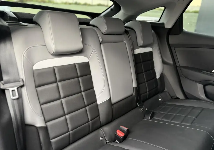 Vue intérieure de la banquette arrière bicolore gris clair et noir avec appuie-têtes et ceintures visibles sur Citroën C4 Hybrid.