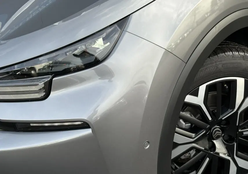 Gros plan sur l'avant droit gris Mercury du Citroën C4 2025, mettant en valeur le phare LED et la jante alliage diamantée.