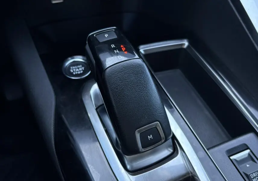 Le levier de vitesses automatique noir du Peugeot 5008 2022 vu en gros plan dans l'habitacle gris.