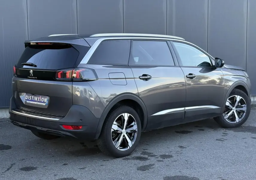 Peugeot 5008 gris Platinium en 3/4 arrière droit, avec jantes alliage bi-ton et vitres surteintées.