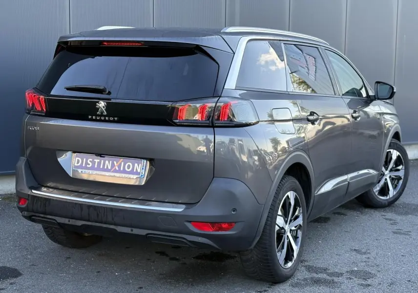Peugeot 5008 gris Platinium en 3/4 arrière droit, avec jantes alliage bicolores et vitres arrière surteintées.