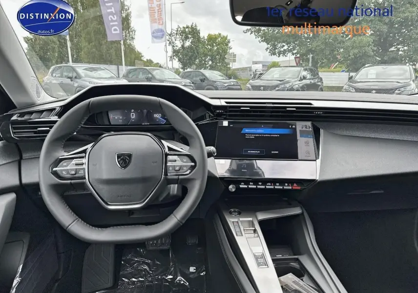 Vue intérieure du tableau de bord et volant multifonction de la Peugeot 308 noire, avec écran tactile central allumé.