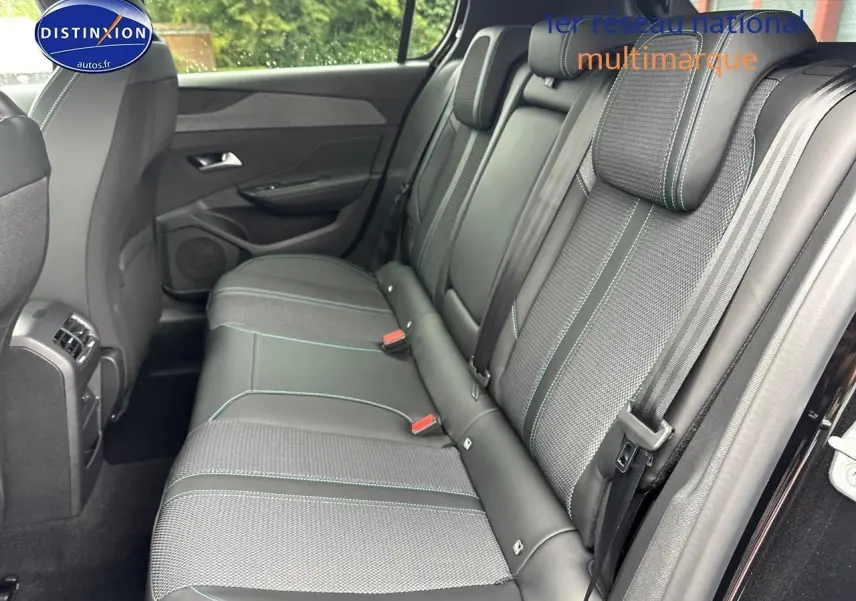 Vue intérieure sur la banquette arrière droite de la Peugeot 308 noire avec sellerie tissu et cuir aux surpiqûres vertes.