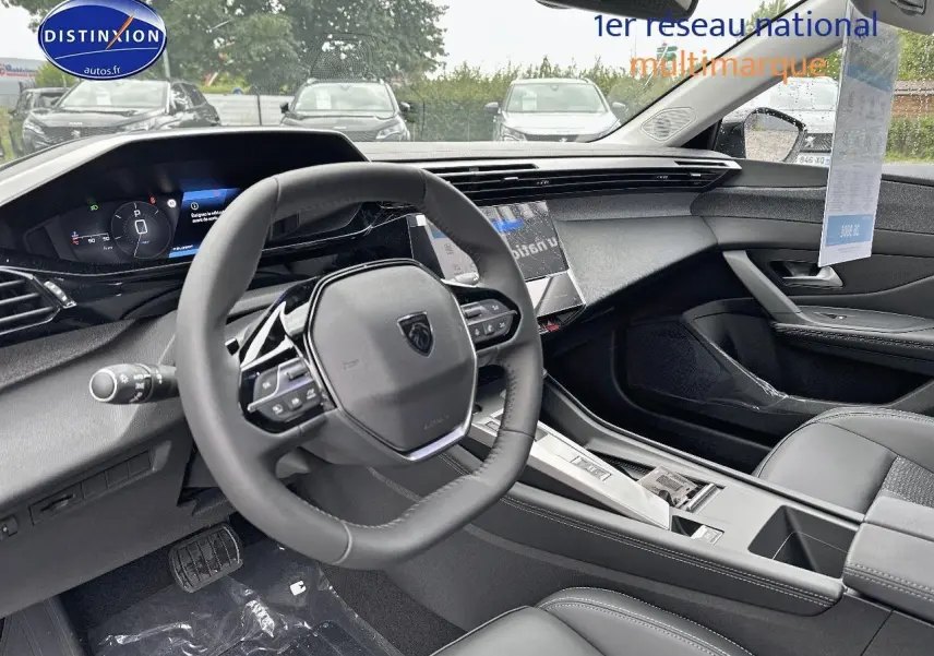 Intérieur noir de la Peugeot 308 2025, vue côté conducteur sur le volant multifonction et tableau de bord digital.