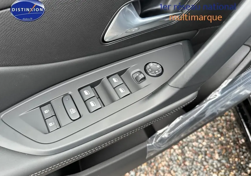 Gros plan sur la commande des vitres électriques et rétroviseurs côté conducteur d'une Peugeot 308 noire 2025
