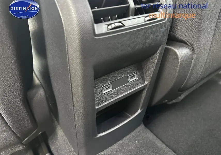 Prise USB arrière noire de la Peugeot 308 2025 vue en gros plan entre les sièges arrière.