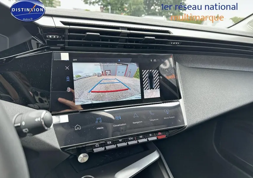 Vue rapprochée de l'écran tactile central affichant la caméra de recul dans l'habitacle d'une Peugeot 308 noire.