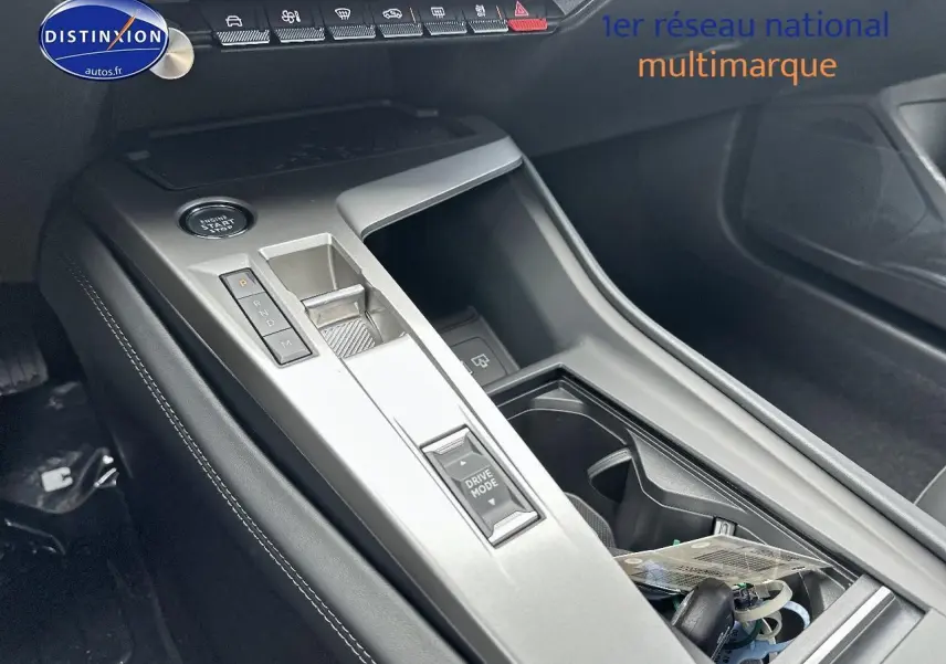 Vue rapprochée de la console centrale noire de la Peugeot 308 1.5 BlueHDi 130 Allure EAT8 avec levier de vitesses électronique.