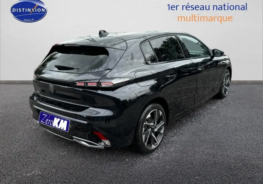 Vue 3/4 arrière droite d'une Peugeot 308 noire brillante avec feux arrière LED et jantes alliage distinctives.