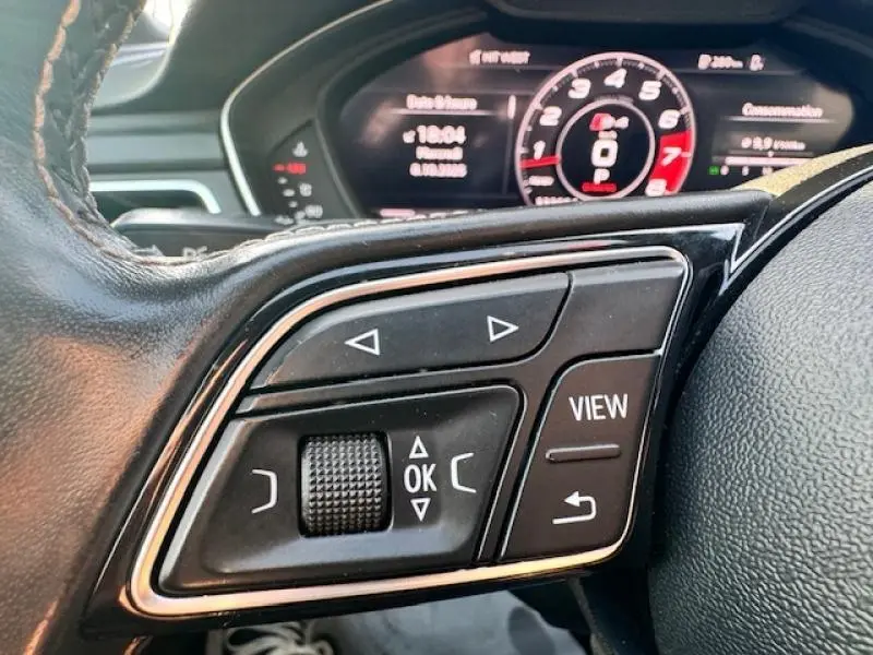 Gros plan sur les commandes au volant côté gauche de l'Audi S4 Avant 2017 avec tableau de bord numérique en arrière-plan.