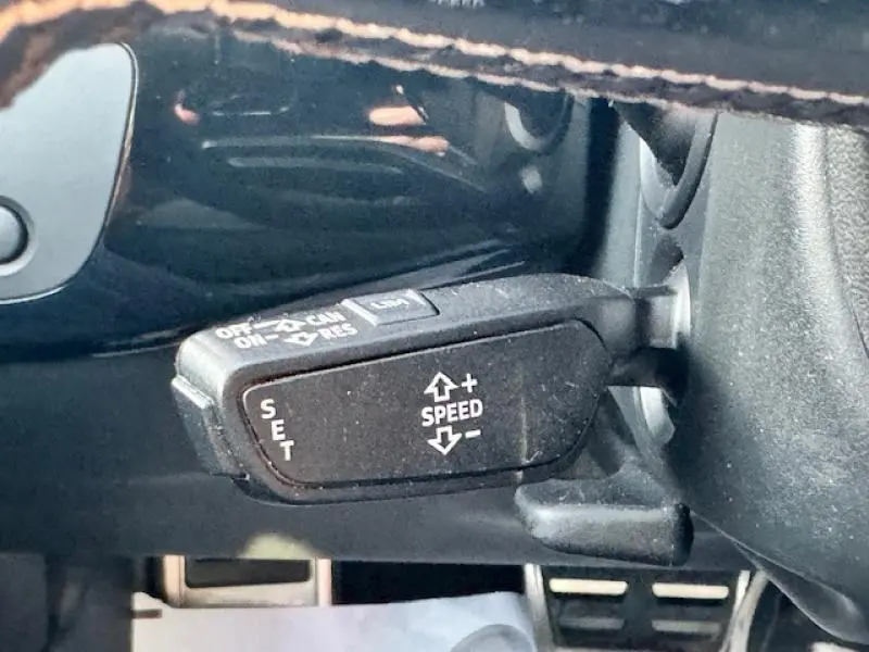 Gros plan sur la commande de régulateur de vitesse au volant d'une Audi S4 Avant 2017, intérieur noir.