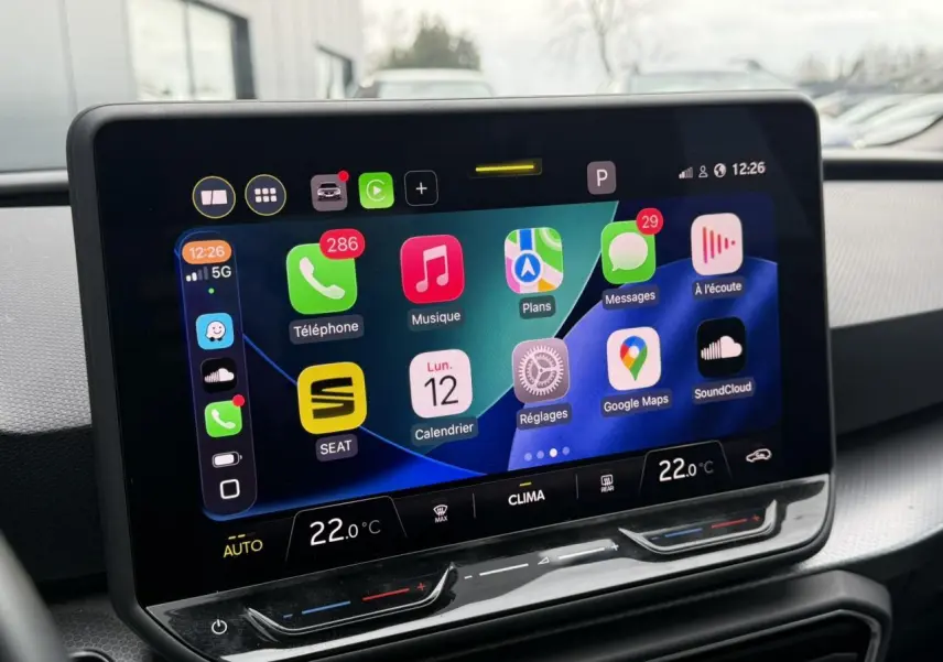 Écran tactile central du tableau de bord du SEAT Leon 2025 affichant les applications connectées et la climatisation à 22°C.