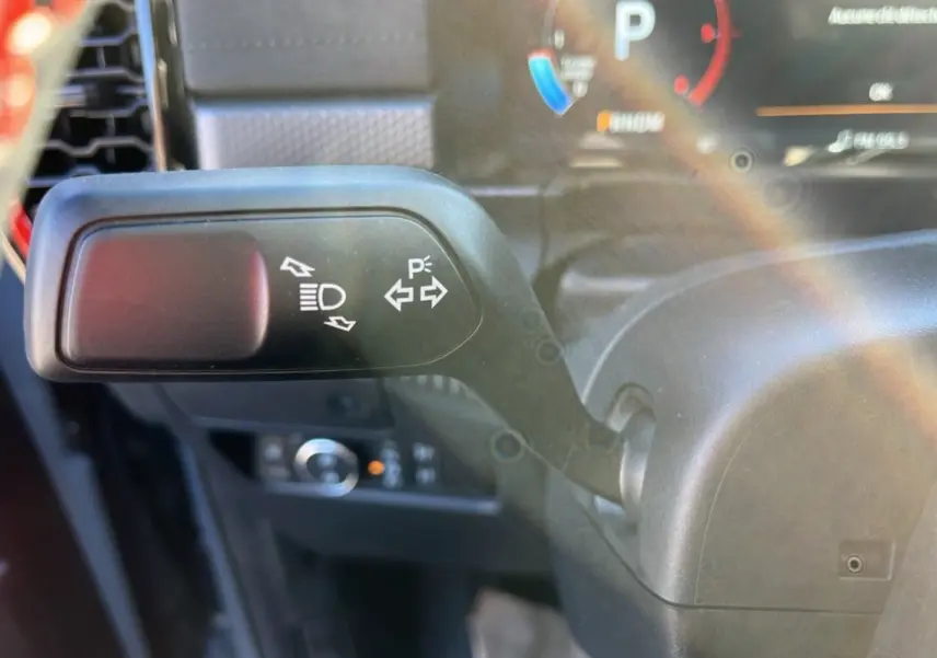 Gros plan sur le commodo gauche du Ford Ranger Raptor gris commandeur, avec commandes des feux et clignotants visibles.