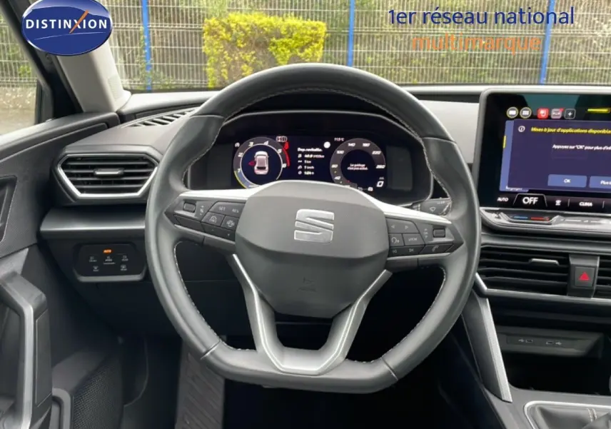 Vue frontale centrée sur le volant cuir et le tableau de bord numérique de la SEAT LEON 2.0 TDI gris métallique.
