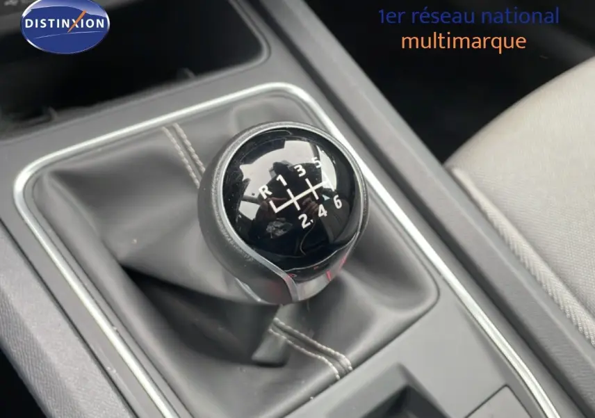 Le levier de vitesses manuel noir de la SEAT LEON 2.0 TDI gris magnétique, avec coutures apparentes, vue intérieure rapprochée.