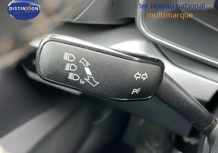 Gros plan sur la commande de clignotants et feux du SEAT LEON 2.0 TDI 115CH STYLE XL, intérieur gris noir.