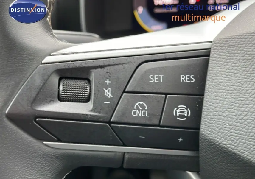 Gros plan sur les commandes au volant d'une SEAT LEON gris magnétique, version 2.0 TDI 115CH STYLE XL, boutons de régulateur de vitesse.