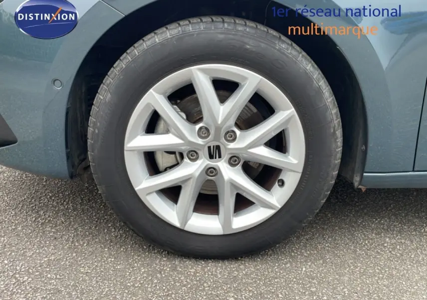 Gros plan sur la roue avant gauche d'une SEAT LEON gris magnétique métal, mettant en valeur la jante alliage 16 pouces.