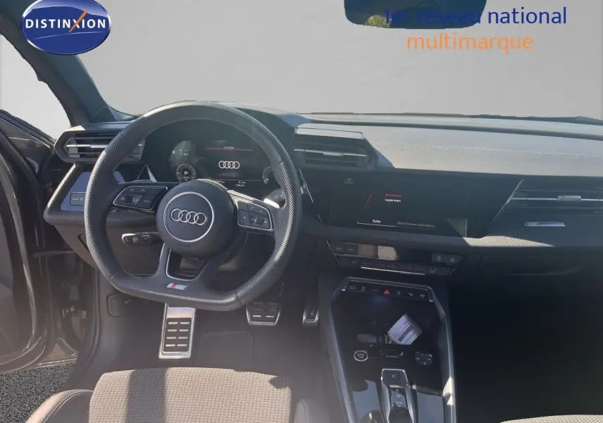 Vue intérieure de l'Audi A3 Sportback 40 TFSIe S-Line 2025, tableau de bord et volant noir avec finitions modernes.