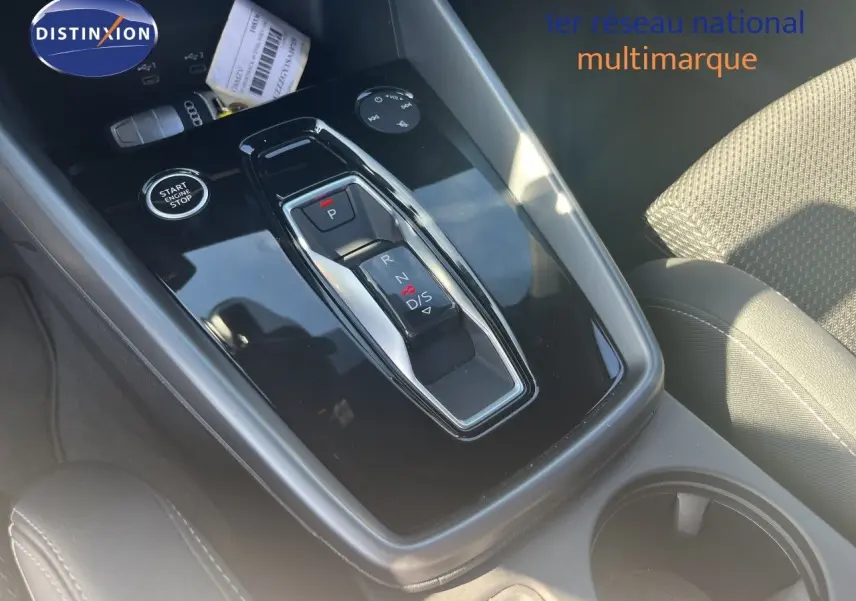 Gros plan sur la console centrale de l'Audi A3 Sportback 40 TFSIe, avec levier de vitesse automatique et bouton start/stop.