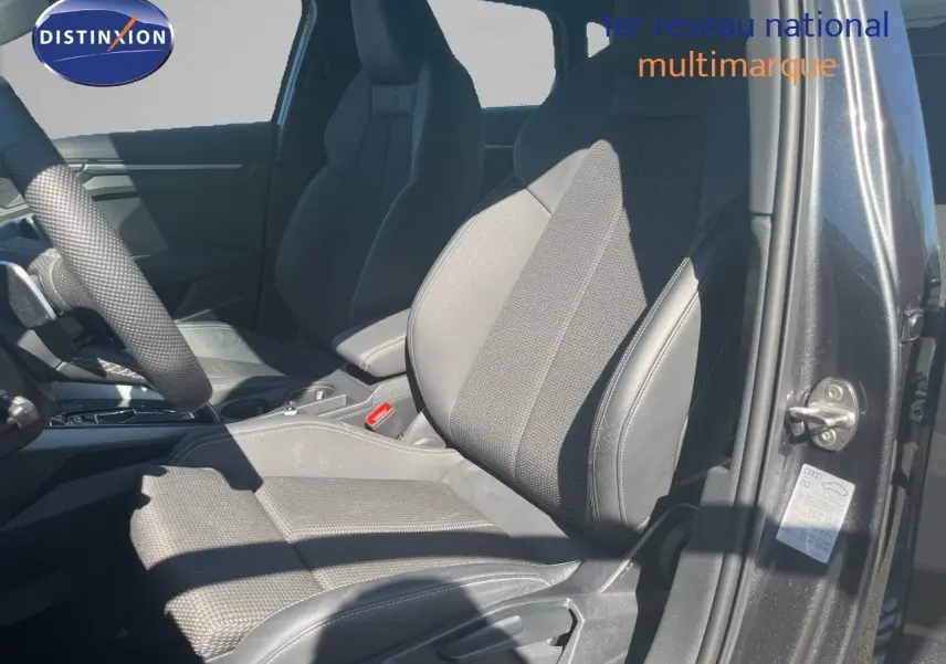 Vue intérieure côté conducteur de l'Audi A3 Sportback 40 TFSIe S-Line 2025, sièges en tissu et cuir noir.