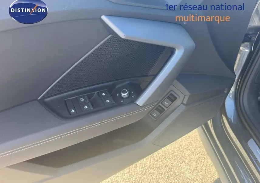 Détail de la porte avant gauche de l'Audi A3 Sportback gris Daytona, avec commandes des vitres et rétroviseurs.