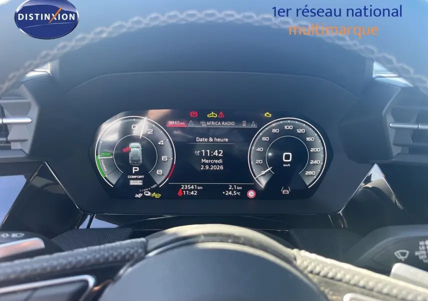 Vue rapprochée du tableau de bord numérique de l'Audi A3 Sportback 40 TFSIe gris Daytona, affichant vitesse et informations.