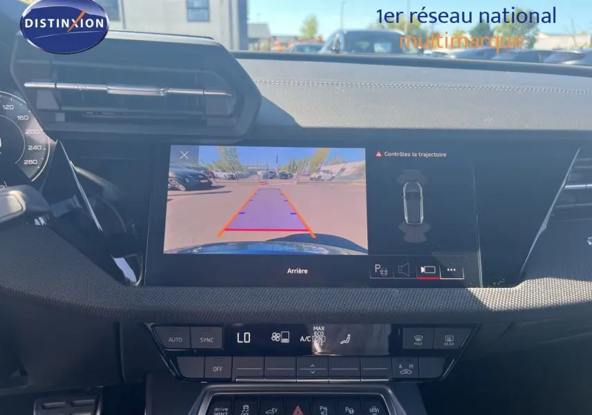 Vue intérieure du tableau de bord de l'Audi A3 Sportback gris Daytona, écran affichant la caméra de recul et les commandes climatiques.