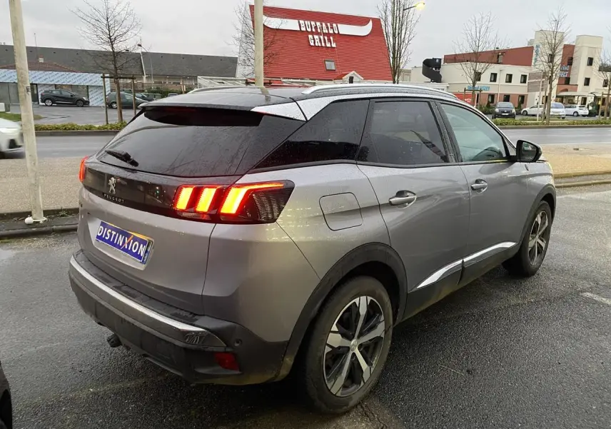 Peugeot 3008 gris Artense vue 3/4 arrière droit, feux arrière allumés et toit noir Perla Nera.