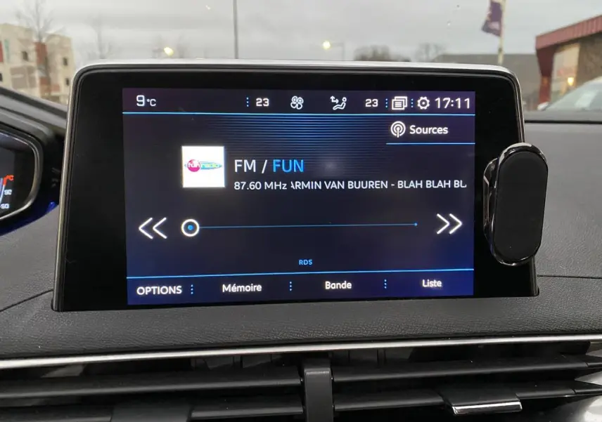 Écran tactile central du Peugeot 3008 gris Artense, affichant la radio FM avec interface moderne et commandes tactiles.
