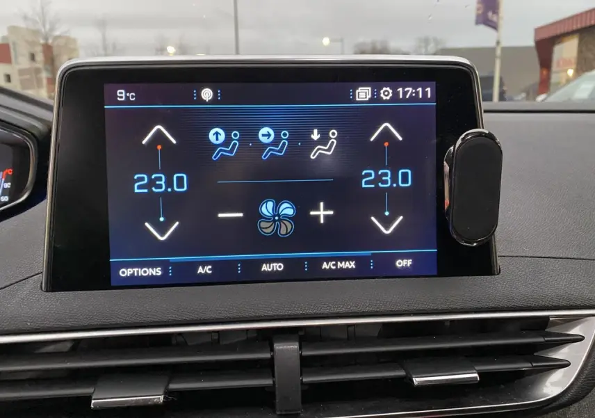 Écran tactile central du tableau de bord du Peugeot 3008 affichant la climatisation à 23°C en mode automatique.