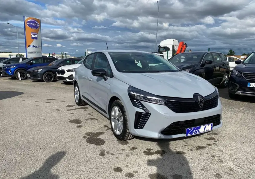 Renault Clio gris Rafale vue 3/4 avant droit, avec calandre noire et feux LED distinctifs, stationnée en extérieur.