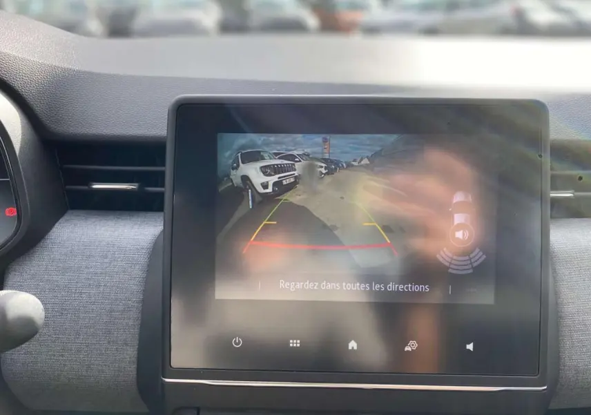 Écran tactile central affichant la caméra de recul de la Renault Clio 2025, avec vue arrière et guidage coloré.