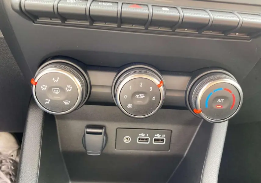 Gros plan sur les commandes de climatisation et ports USB du tableau de bord de la Renault Clio gris Rafale 2025.