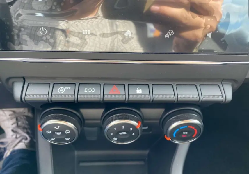 Gros plan sur la console centrale de la Renault Clio 2025 gris Rafale, montrant les commandes de climatisation manuelle et les boutons de fonction.