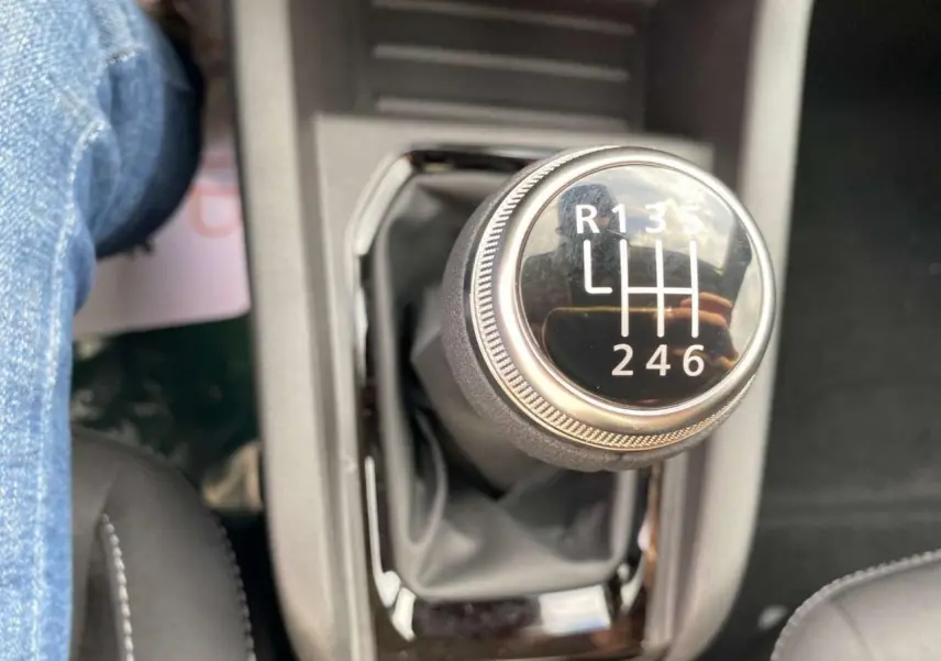 Le levier de vitesse manuel de la Renault Clio gris Rafale, vu en gros plan depuis l'intérieur côté conducteur.