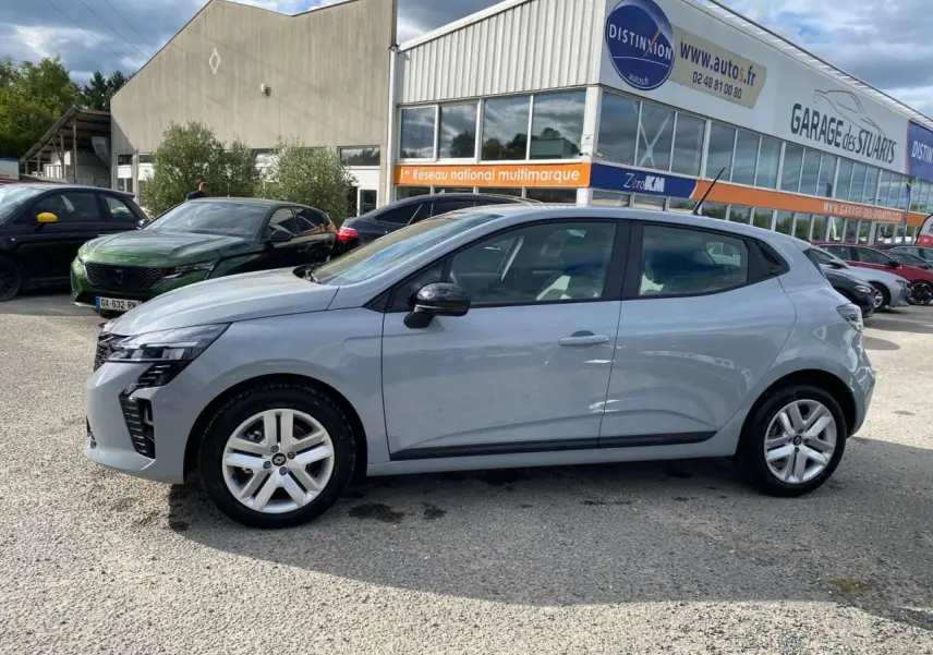 Profil latéral droit de la Renault Clio 2025 gris Rafale, avec jantes alliage et lignes modernes visibles en extérieur.