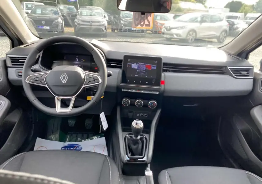 Vue intérieure avant de la Renault Clio 2025 gris Rafale, avec tableau de bord moderne et écran tactile central.