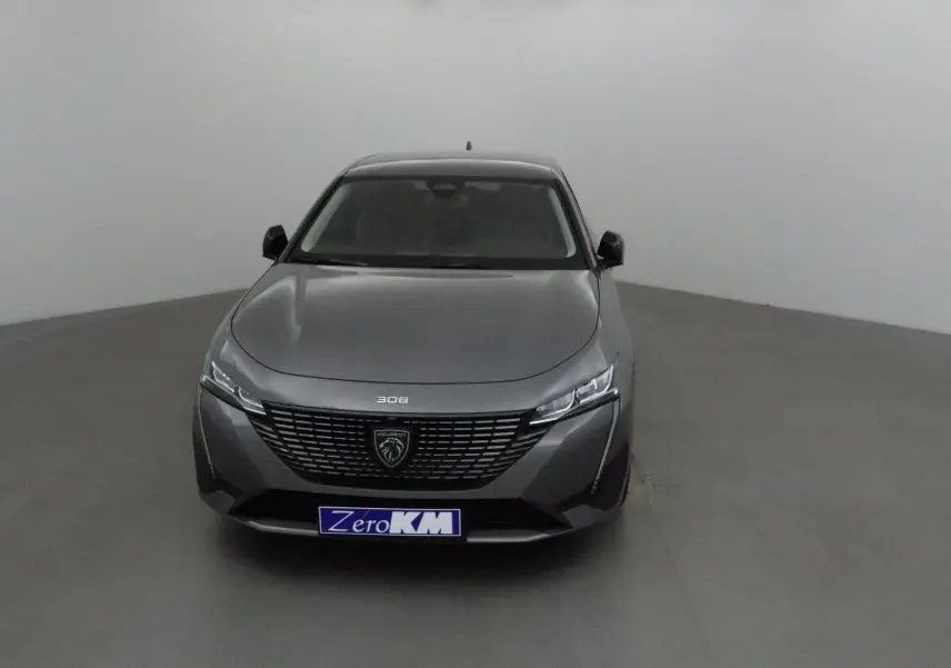 Vue frontale d'une Peugeot 308 gris Sellenium 2025 avec calandre noire et logo lion central bien visible.