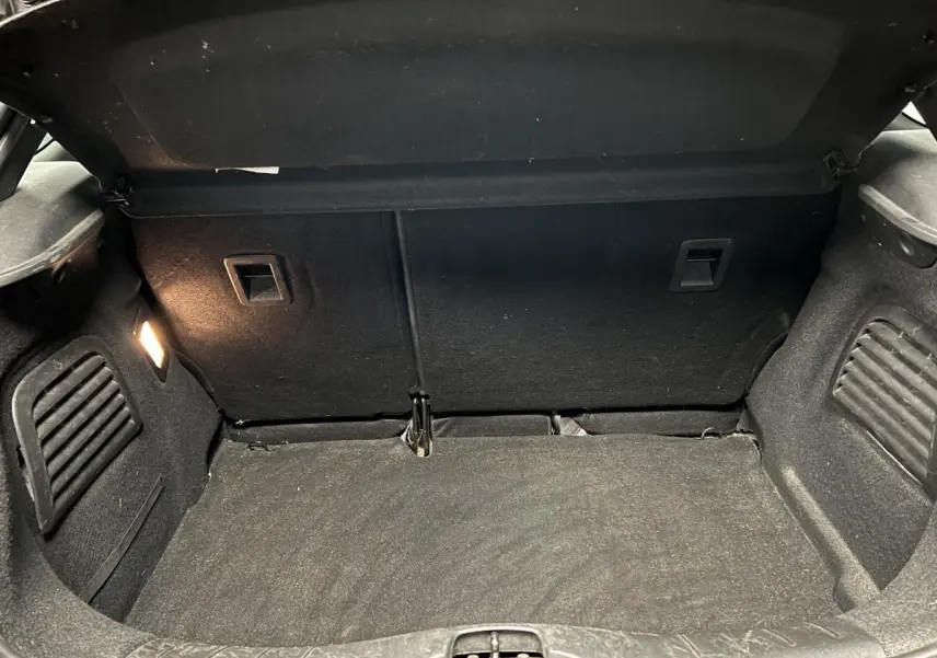 Coffre ouvert de DS3 violet 2016, vue intérieure montrant le tapis et l'éclairage latéral gauche.