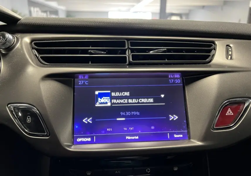 Écran tactile central allumé affichant la radio dans l'habitacle du DS3 violet de 2016, vue de face rapprochée.