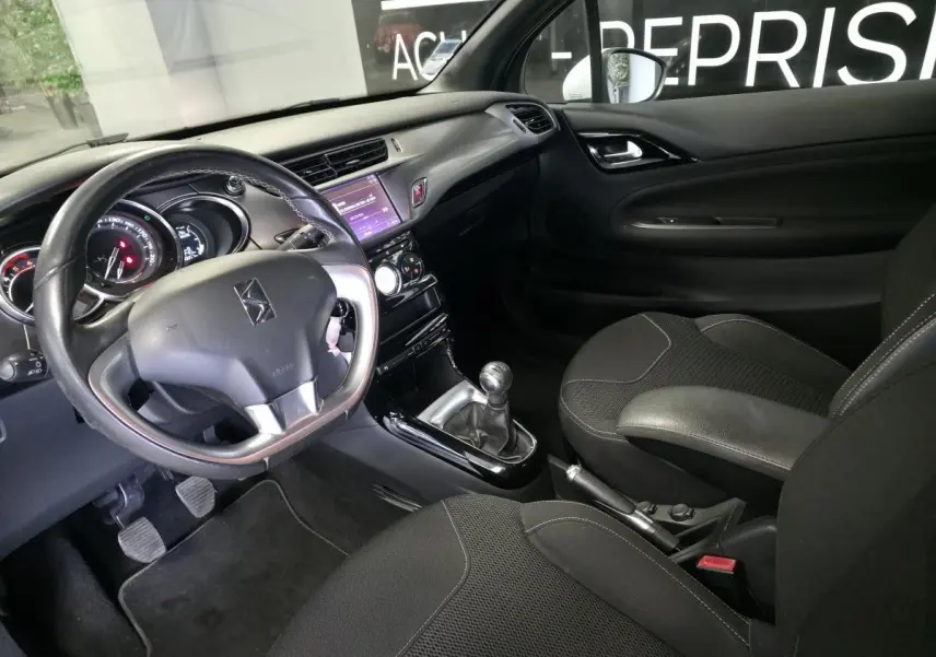 Intérieur noir de DS3 2016, vue côté conducteur avec volant cuir, tableau de bord et console centrale tactile.