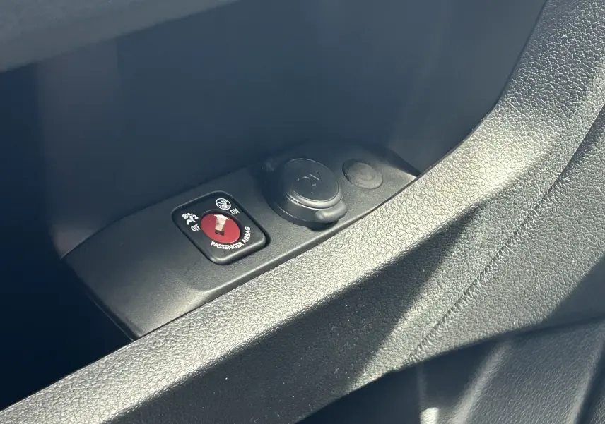Gros plan sur le bouton de désactivation de l'airbag passager et prise 12V dans l'habitacle du Citroën Jumpy gris titane.