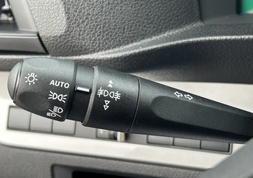 Gros plan sur la manette de commande des phares et clignotants dans l'habitacle du Citroën Jumpy gris titane.