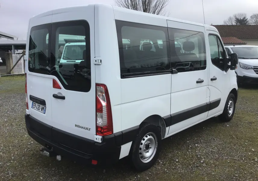 Vue 3/4 arrière droite d’un Renault Master Combi III blanc de 2017 avec vitres latérales teintées et attelage.